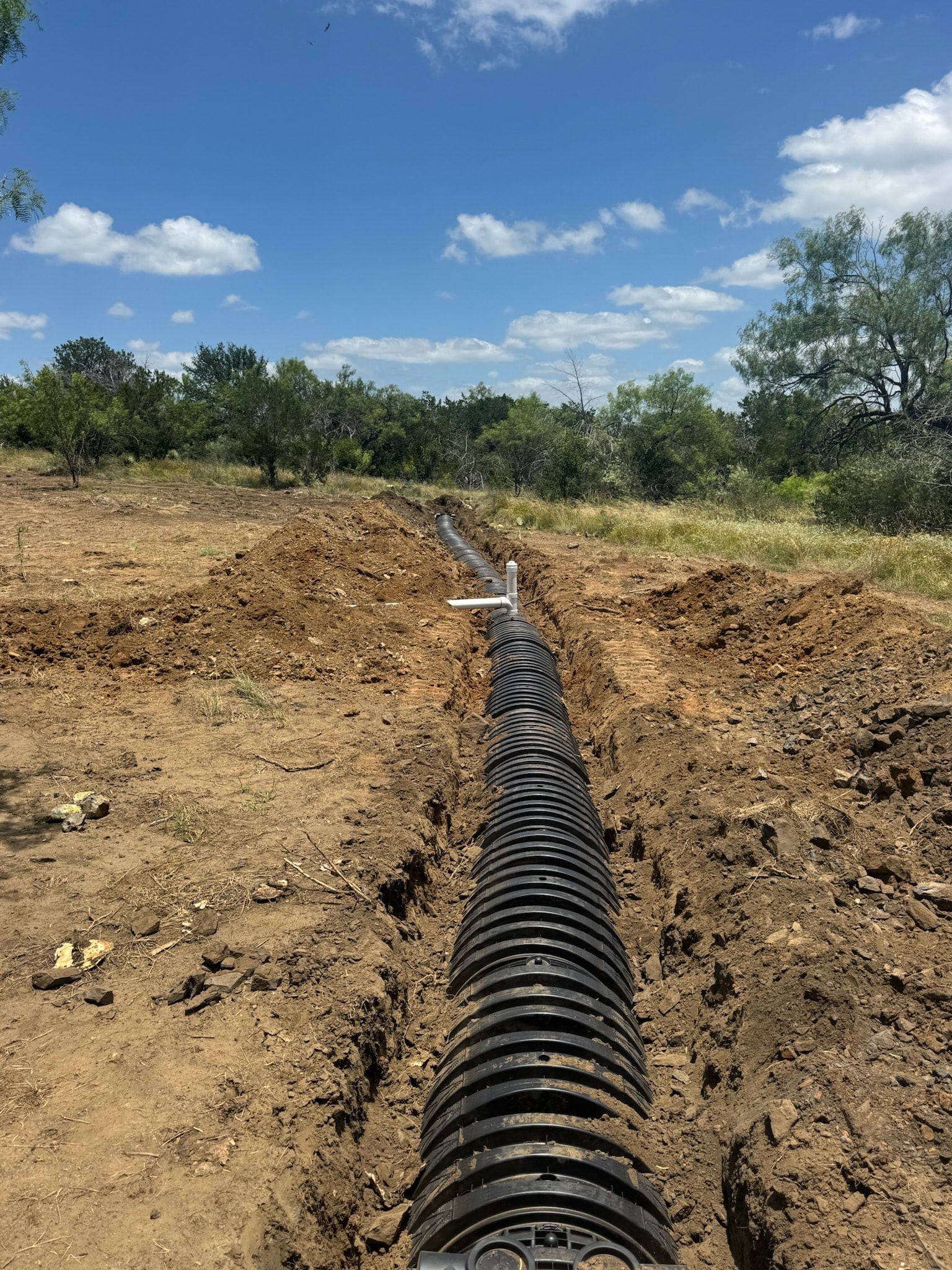 Underground drainage pipe installation in excavated trench