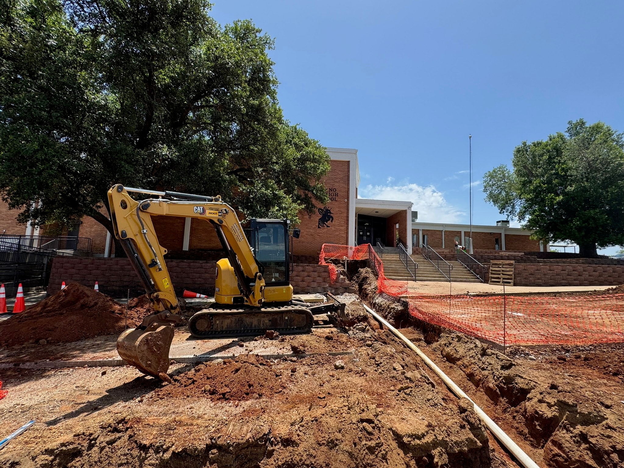 CAT excavator digging trench at construction site
