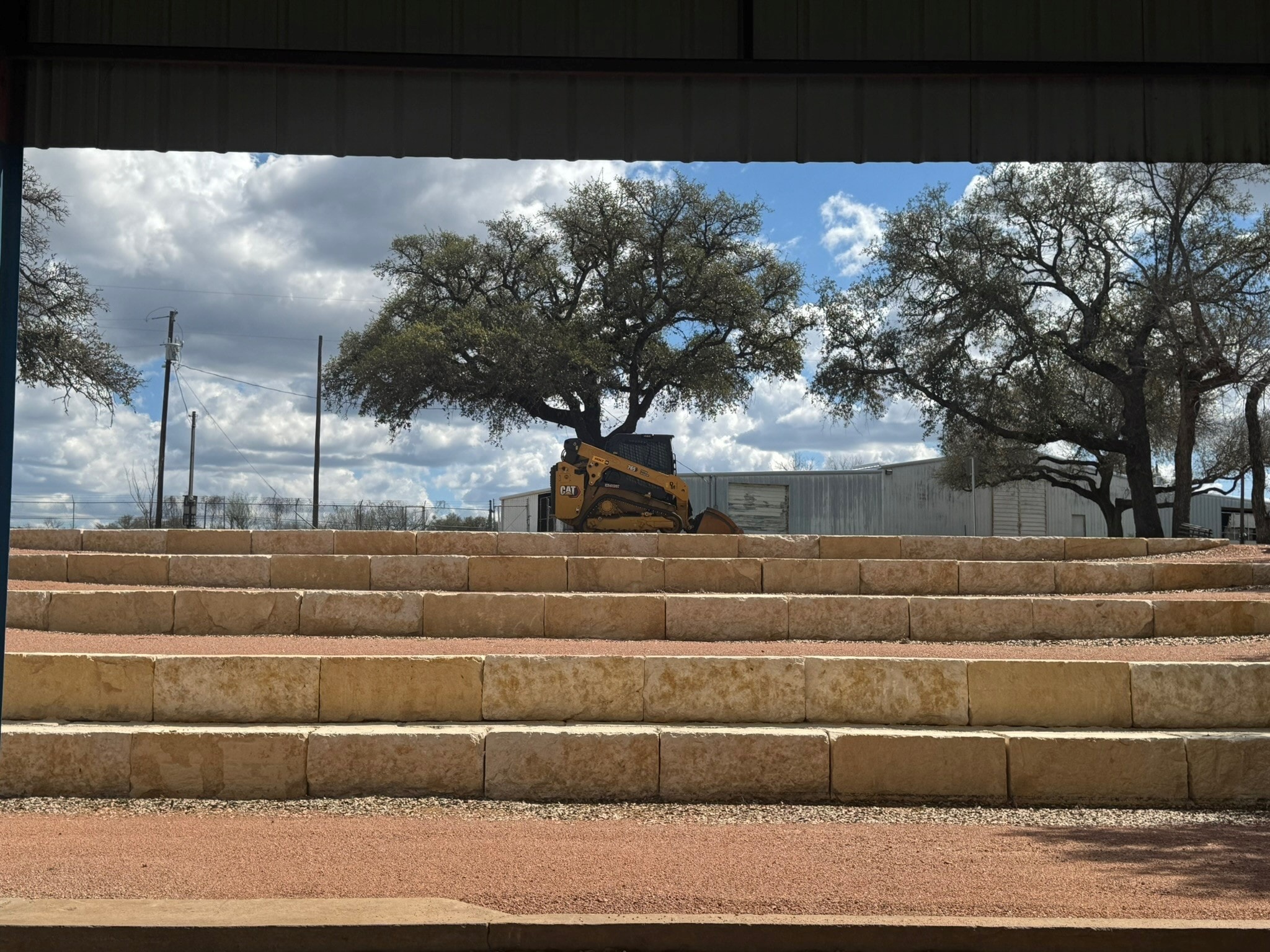 Limestone retaining wall construction with CAT skid steer