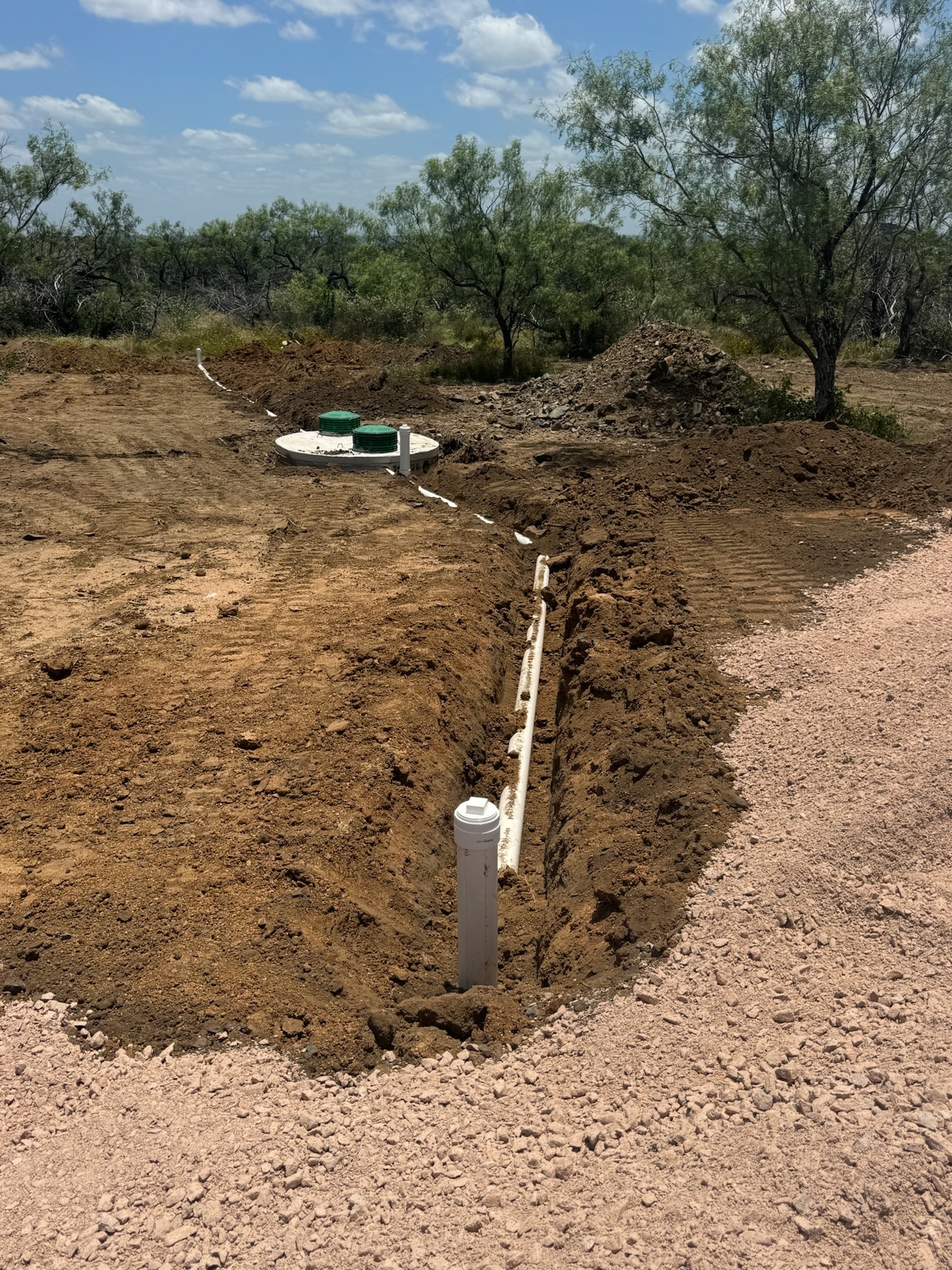 Septic system installation with tank and drain field trench in Texas